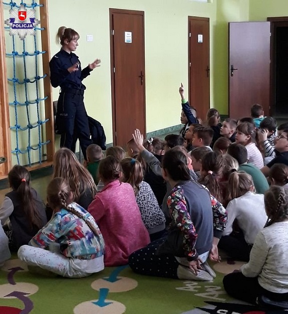 Policjantka przekazuje dzieciom zasady bezpiecznego przebywania na stoku.