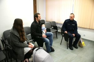 rodzice z małym dzieckiem z wizytą u policjantów