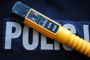 alcoblow - urządzenie do pomiaru stanu trzeźwości leżące na bluzie z napisem Policja