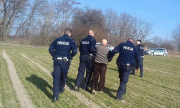 trzej policjanci razem z odnalezionym mężczyzną idę przez pole