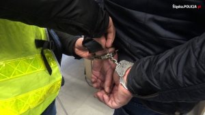 policjant zakłada kajdanki zatrzymanej