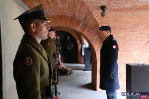 przedstawiciel służby mundurowej składa wieniec pod tablicą pamięci podczas uroczystości Dnia Pamięci Ofiar Zbrodni Katyńskiej