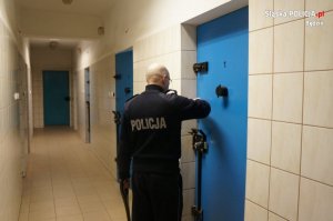 policjant zamyka drzwi celi