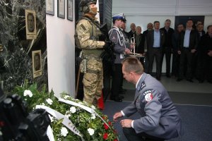 umundurowany policjant składa wieniec pod tablicą pamięci podczas uroczystości 23. rocznicy tragicznie zmarłego na służbie podkom. Piotra Molaka