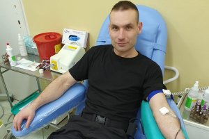 Młody policjant ze Szkoły Policji w Słupsku oddaje krew na fotelu w Centrum Krwiodawstwa i Krwiolecznictwa w Słupsku.