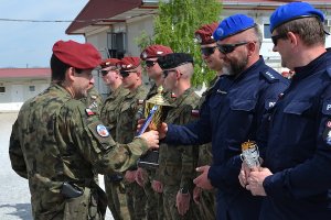 Komisarz Jacek Banaszkiewicz otrzymuje puchar za zdobycie pierwszego miejsca w strzelaniu z pistoletu wojskowego.