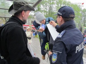 Obrazek przedstawia Komendanta Miejskiego Policji w Tychach, który przekazał 6-letniemu Jasiowi puszkę, w której były słodycze