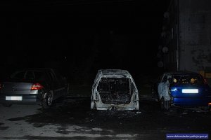 karoseria samochodu osobowego, która uległa spaleniu oraz nadpalone dwa inne pojazdy zaparkowane po obu stronach