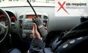 policjant w radiowozie trzyma krótkofalówkę