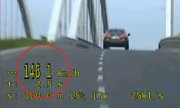 samochód wjeżdżający na most w mieście z prędkością 146,1 km/ h. W kołku zaznaczony napis: 146,1 km/h
