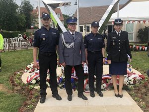 francuska policjantka i troje polskich policjantów, za nimi pomnik poświęcony polskim lotnikom