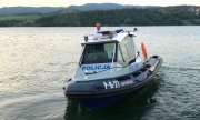 policjant w łodzi policyjnej na jeziorze