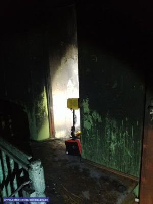 Drzwi do mieszkania po pożarze widoczne z klatki schodowej