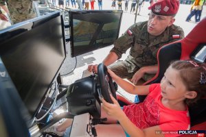 Dzień otwarty Centrum Szkolenia Policji w Legionowie – stoisko Żandarmerii Wojskowej, dziecko na symulatorze
