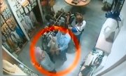 kobieta ogląda ciuchy w sklepie, a drugą ręką kradnie - wyciąga z plecaka Egipcjanki portfel i okulary