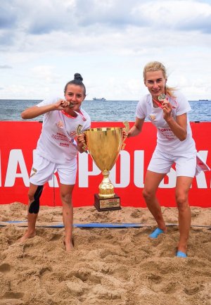 Dwie uczestniczki zawodów o Puchar Polski w Beach Soccerze kobiet z medalami i pucharem