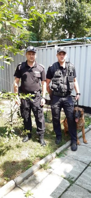 dwaj policjanci z psem służbowym