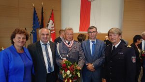 mł. insp. Wiesław Gom odznaczony orderem w towarzystwie trzech mężczyzn i kobiety