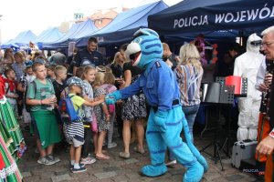 dzieci przy stoisku, z maskotką policji: niebieski Tygrys