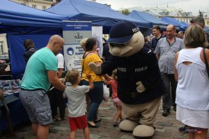 policyjna maskotka: sierżant Pyrek z Poznania przybija piątkę z dzieckiem