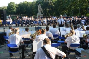 koncert orkiestry policyjnej (muzycy w białych koszulach), widok zza orkiestry, w tle publiczność