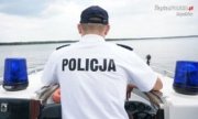 Na zdjęciu widoczny jest policjant wraz ze służbową łodzią motorową