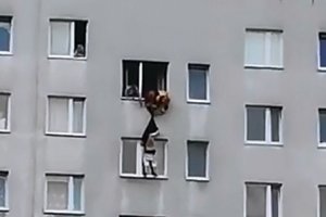 Zdjęcie przedstawia mężczyznę, który chciał popełnić samobójstwo skacząc z parapetu oraz akcję służb ratowniczych