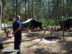 policjant przemawia do dzieci na obozie harcerskim