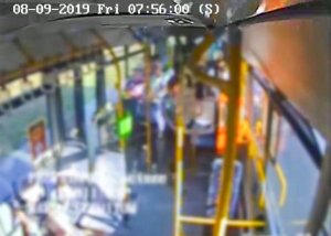 Zdjęcie przedstawia wnętrze autobusu z jadącymi nim pasażerami.