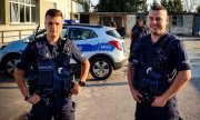 dwóch umundurowanych policjantów, którzy odnaleźli 67-latka w tle radiowóz policyjny