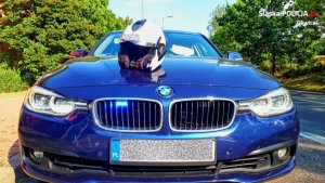 Nieoznakowany radiowóz BMW i kask motocyklowy na jego masce