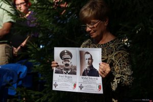10. Uroczystości na cmentarzu w Miednoje - kobieta trzyma zdjęcia zamordowanych