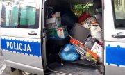 Na zdjęciu widnieje radiowóz policyjny, w którym znajdują się rzeczy zebrane przez dzielnicowe dla potrzebujących.