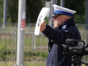 policjant z ręką wyciągniętą w bok - zdjęcie od tyłu