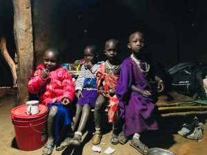 Dzieci z Tanzanii siedzą w oświetlonym domu&quot;&gt;
