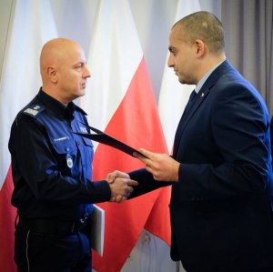 komendant główny policji przyjmuje dyplom od ambasadora