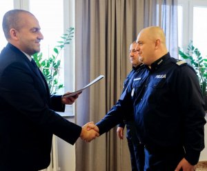 ambasador wręcza dyplom policjantowi