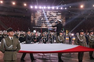 koncert piosenki żołnierskiej, na pierwszym planie żołnierze trzymają flagę Polski