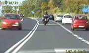 motocyklista jadący drogą wśród samochodów