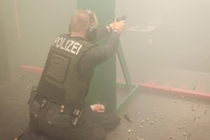 Niemiecki policjant strzela za osłony.