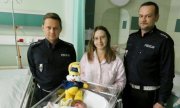 dwaj policjanci z kobietą oraz nowo narodzonym dzieckiem