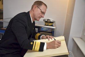 Wiceadmirał Yancy Linsey wpisuje ię do księgi honorowej szkoły policji.