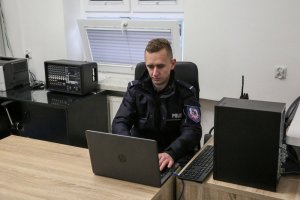 Policjant na dyżurce obsługujący komputer