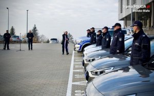 Policjanci, stojący obok samochodów