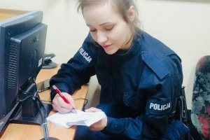 Młoda policjantka dokonuje wpisów w notatniku.