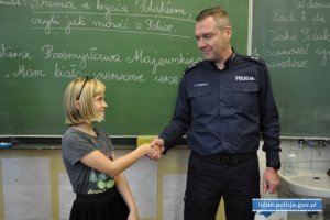 Zastępca komendanta gratuluje dziewczynce