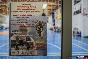 zawieszony na hali sportowej plakat informujący o charytatywnym turnieju piłki nożnej halowej