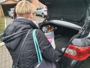 Policjantka pakuje prezenty do bagażnika samochodu
