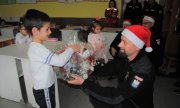 policjant wręcza chłopczykowi paczkę świąteczną