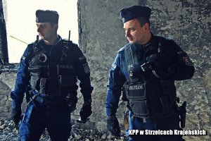 dwaj policjanci w trakcie sprawdzania pustostanu